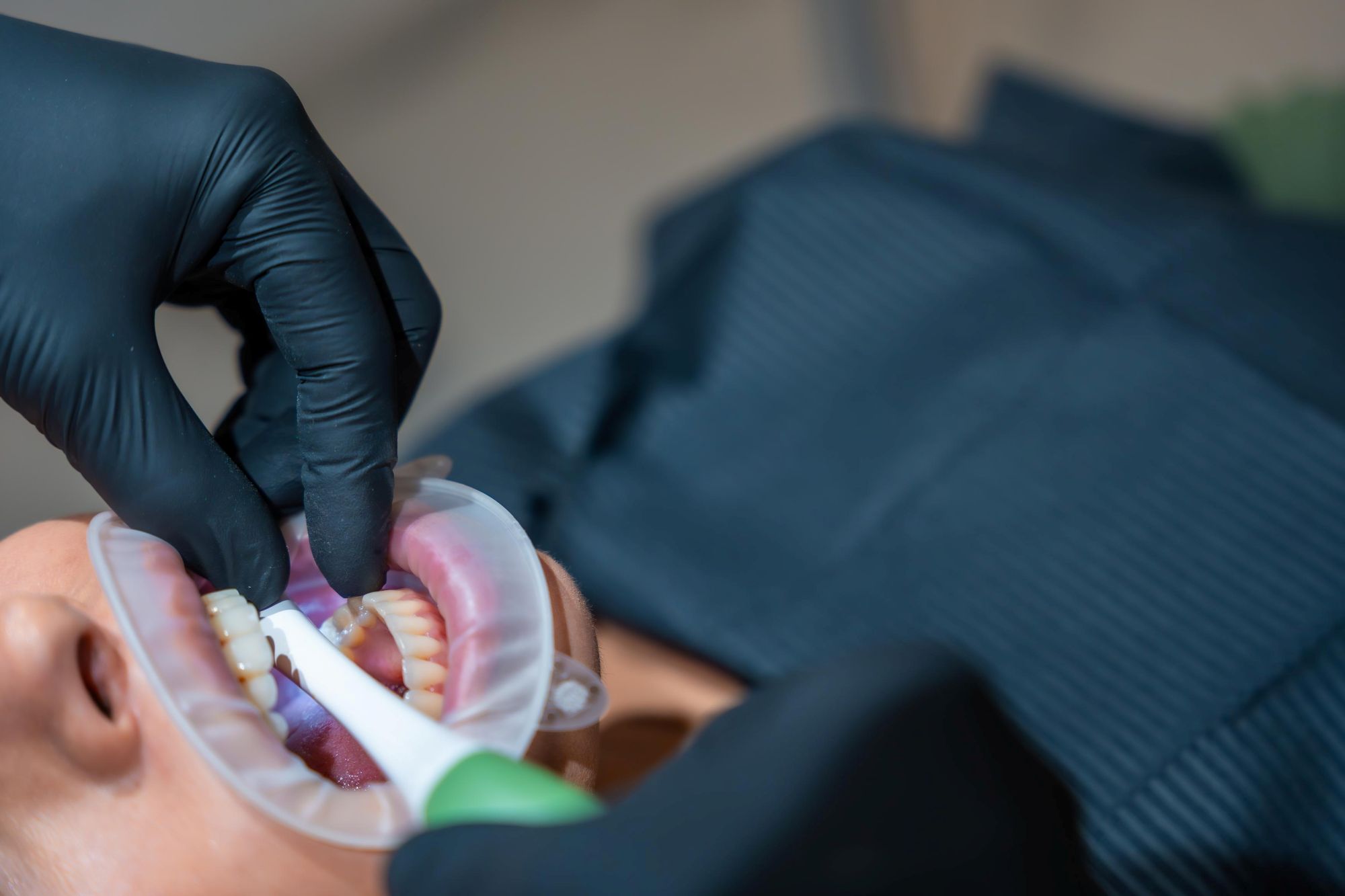 Dental professional wearing protective clothing during periodontal deep cleaning treatment