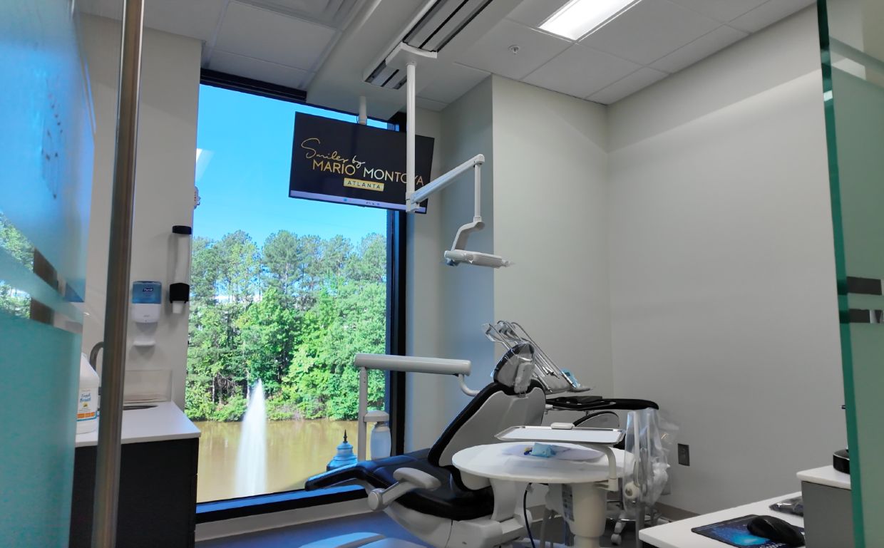 Bright dental treatment room featuring clinical equipment and digital technology at Smiles by Mario Montoya