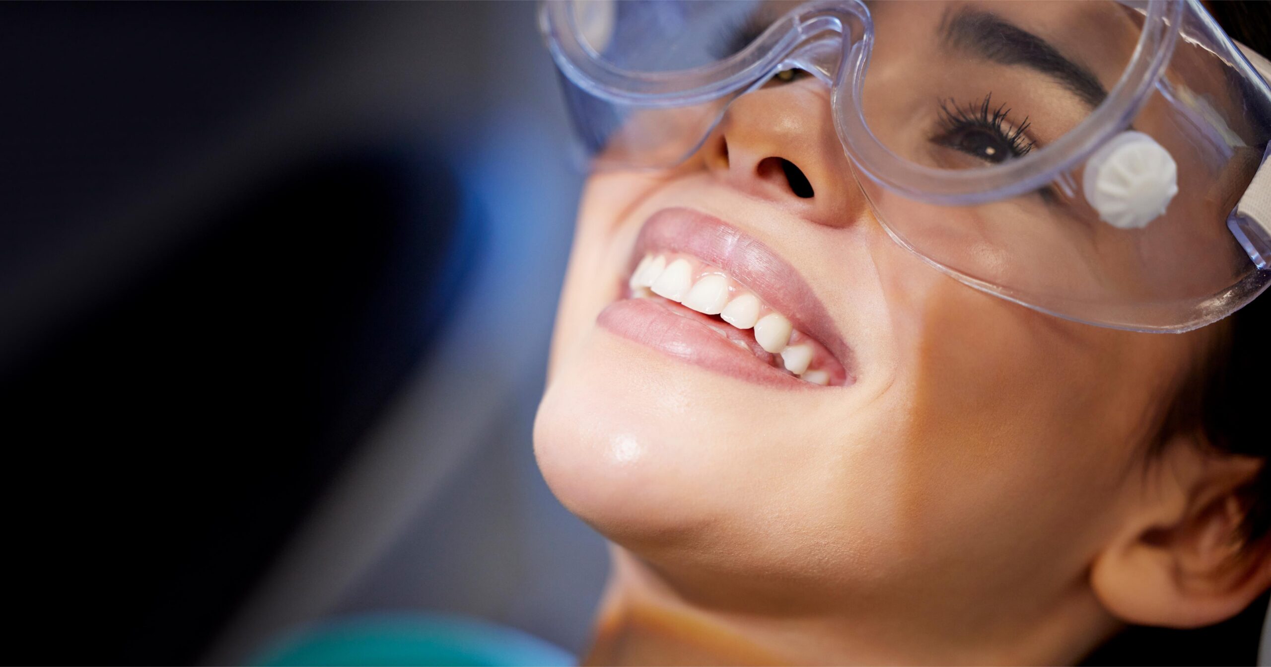 Woman wearing protective eyewear during a dental procedure in a modern clinical setting
