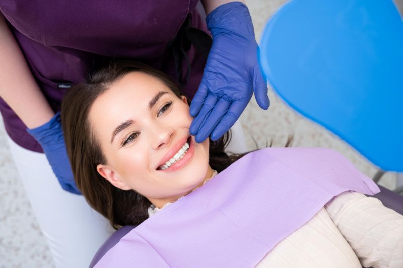 Woman receiving composite dental bonding treatment from a dental professional wearing blue gloves