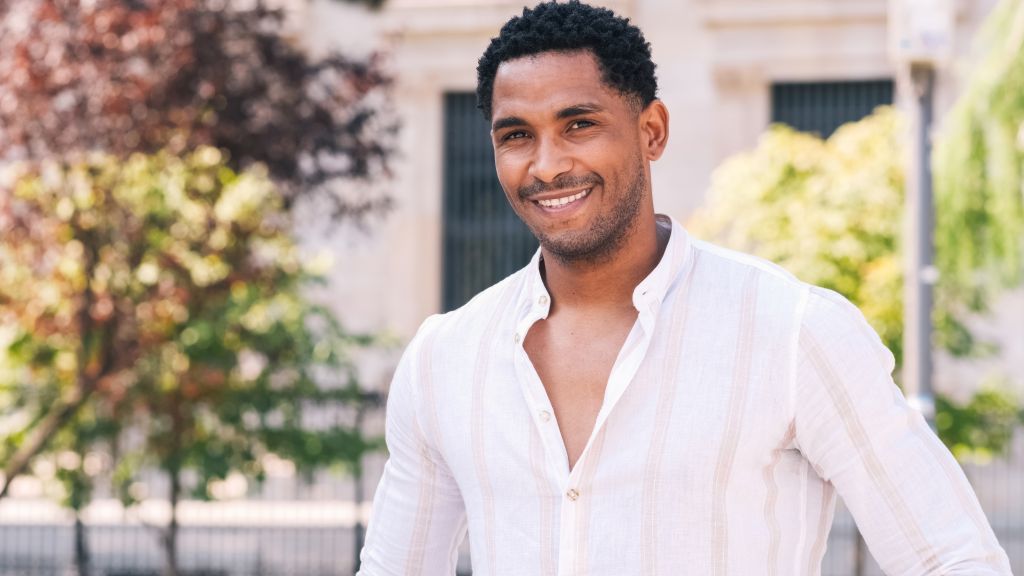 Smiling man in a light-colored shirt outdoors, representing healthy and confident smiles